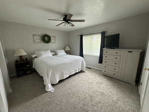 Carpeted bedroom with ceiling fan