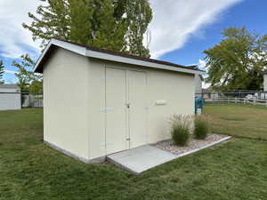 View of outbuilding featuring a lawn