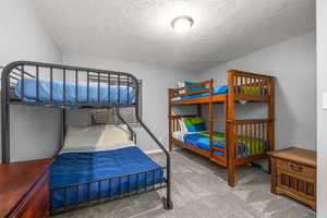 Carpeted bedroom featuring a textured ceiling