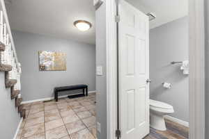 Bathroom with wood-type flooring, toilet, and a textured ceiling