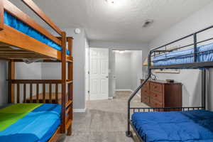 Carpeted bedroom featuring a textured ceiling