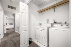 Laundry area featuring independent washer and dryer, carpet flooring, and a textured ceiling