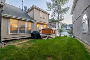 Rear view of house featuring a yard and a deck