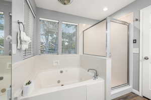 Bathroom featuring hardwood / wood-style flooring and separate shower and tub