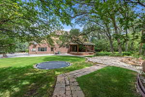 View of yard with a trampoline and a patio area