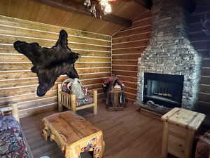 Living room featuring wooden ceiling, vaulted ceiling with beams, hardwood / wood-style flooring, and a fireplace