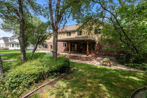 Rear view of house with a patio and a yard