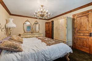 Bedroom featuring carpet, a textured ceiling, and crown molding