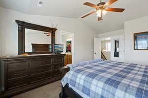 Carpeted bedroom featuring ceiling fan, a closet, a spacious closet, and lofted ceiling