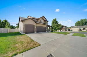 View of front facade featuring a front yard and a garage