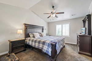 Carpeted bedroom with a textured ceiling, ceiling fan, and lofted ceiling