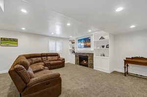 Living room with a fireplace, light carpet, and built in features