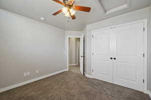 Unfurnished bedroom featuring ceiling fan, a closet, and carpet floors