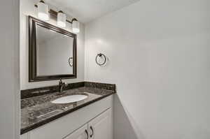 Bathroom with a textured ceiling and vanity