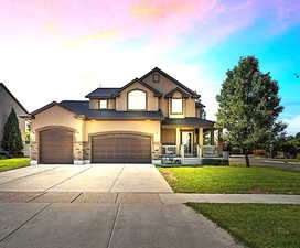 View of front of home with a garage, a porch, and a yard