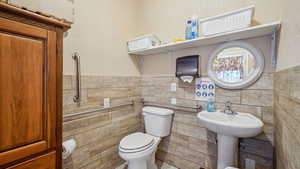 Bathroom with tile walls and toilet