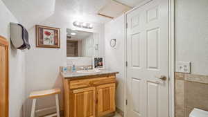 Bathroom featuring a textured ceiling and vanity