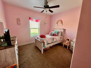 Carpeted bedroom featuring ceiling fan