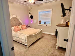 Carpeted bedroom featuring ceiling fan