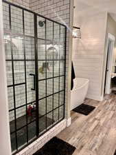 Bathroom featuring plus walk in shower and wood-type flooring