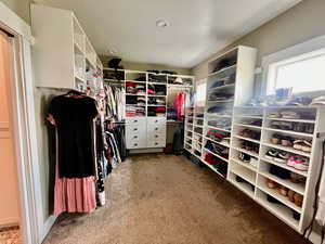 Walk in closet featuring light carpet