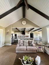 Living room featuring dark wood-type flooring and lofted ceiling with beams