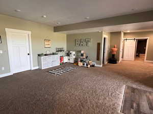 Rec room featuring carpet flooring and a barn door