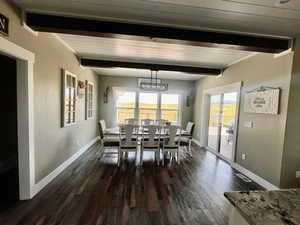 Dining area featuring beamed ceiling and wood-type flooring