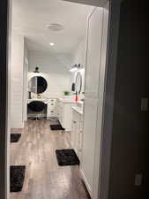 Bathroom with wood walls, vanity, and wood-type flooring