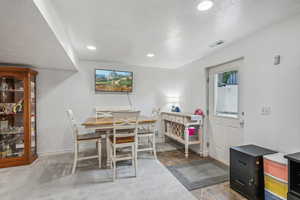 Carpeted dining space featuring a textured ceiling