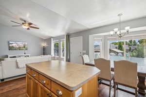 Kitchen with a center island, dark hardwood / wood-style floors, and lofted ceiling