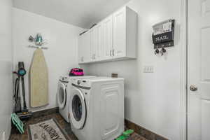 Clothes washing area with washer and dryer and cabinets