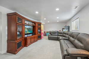 Living room with a textured ceiling and light carpet