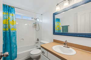 Full bathroom featuring tile patterned floors, vanity, shower / tub combo with curtain, and toilet