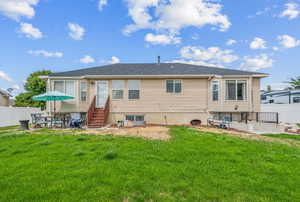 Rear view of house featuring a yard