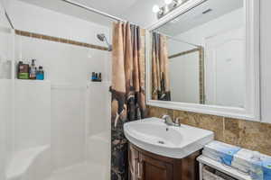 Bathroom featuring a shower with shower curtain and vanity