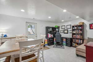 Office space featuring a textured ceiling and light colored carpet