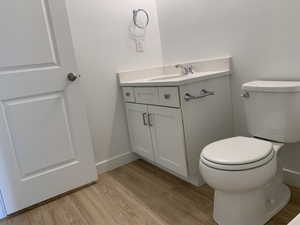 Bathroom with wood-type flooring, toilet, and vanity (photos are not of actual home this is a previously built home)