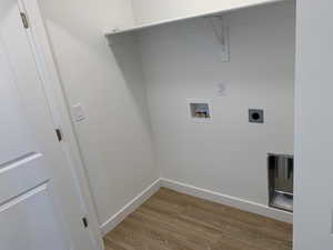 Washroom with hookup for an electric dryer, hookup for a washing machine, and wood-type flooring (photos are not of actual home this is a previously built home)