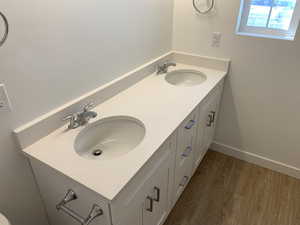 Bathroom with dual vanity and wood-type flooring (photos are not of actual home this is a previously built home)