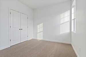 Unfurnished bedroom with carpet flooring and a closet