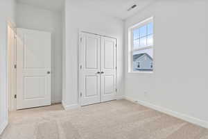 Unfurnished bedroom with a closet and light colored carpet