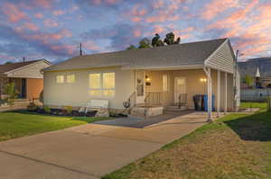 View of front facade featuring a carport and a lawn