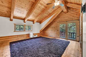 Bonus room with ceiling fan, light hardwood / wood-style flooring, rustic walls, and wood ceiling