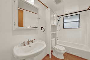 Full bathroom with sink, toilet, shower / bathtub combination, and wood-type flooring