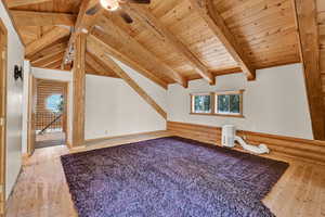 Bonus room featuring light hardwood / wood-style flooring, lofted ceiling with beams, and wood ceiling