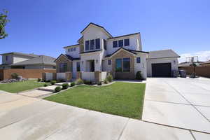 View of front of property with a garage and a front lawn