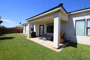 Back of property featuring a patio and a lawn