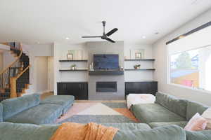 Living room with a tile fireplace and ceiling fan