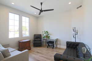 Living room featuring light wood-type flooring and ceiling fan